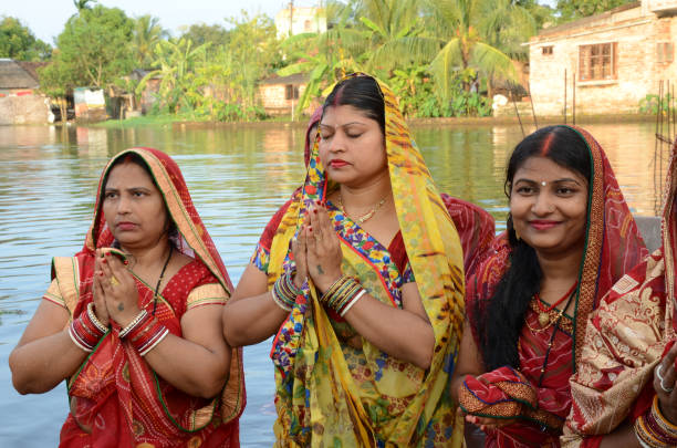 Indian women waiting for sunrise on the occasion of chhath puja festival Indian women waiting for sunrise on the occasion of chhath puja festival. Chhath is a Hindu festival celebrated each year by the people very eagerly. This is very antique festival of the Hindu religion dedicated to the God of energy, also known as Dala Chhath chhath stock pictures, royalty-free photos & images