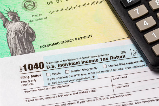 1040 individual income tax return form and economic impact payment or stimulus check. Concept of filing taxes, taxable income and tax information. background, no people stimulus check stock pictures, royalty-free photos & images