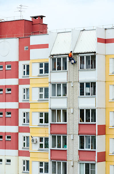 Industrial climber performs sealing of interpanel junctions of building stock photo