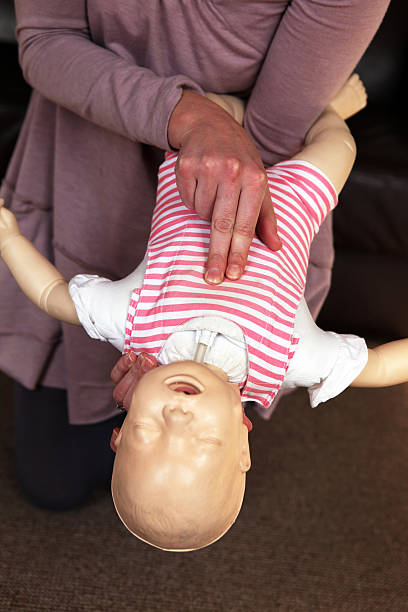 Infant choking training Infant choking training, showing where to push and to hold the baby when choking. choking photos stock pictures, royalty-free photos & images