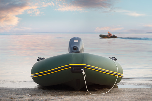 Inflatable boat with outboard motor on the shore