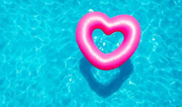 Inflatable rose heart buoy in the swimming pool stock photo