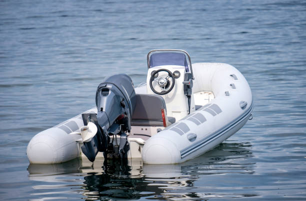 Inflatable White Motor Boat Inflatable White Motor Boat Floating At Sea inflatable raft stock pictures, royalty-free photos & images