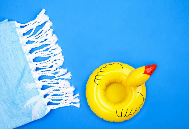 inflatable yellow duck and towel on blue - beach towel imagens e fotografias de stock