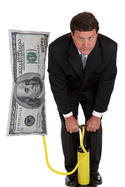 Inflation - Businessman Pumps Up Business stock photo