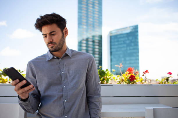 giovane imprenditore informale con il suo smartphone sulla terrazza - correa foto e immagini stock