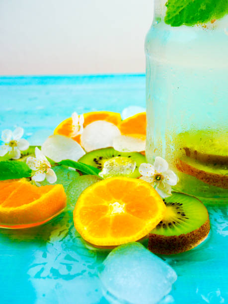 Infused detox water with orange and mint. Ice cold summer cocktail or lemonade in glass mason jar stock photo