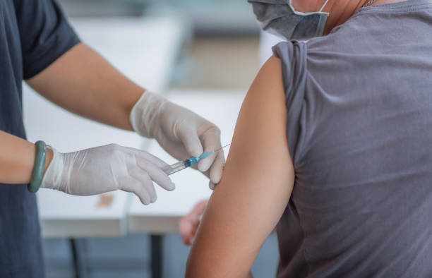 Injections in the arm to treat the disease. The doctor is injecting male patients.In the medical's hand have syringes. vaccination stock pictures, royalty-free photos & images