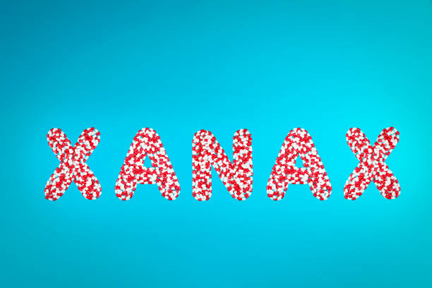 inscription xanax white and red capsules on a blue background top view inscription xanax white and red capsules on a blue background top view xanax pills stock pictures, royalty-free photos & images