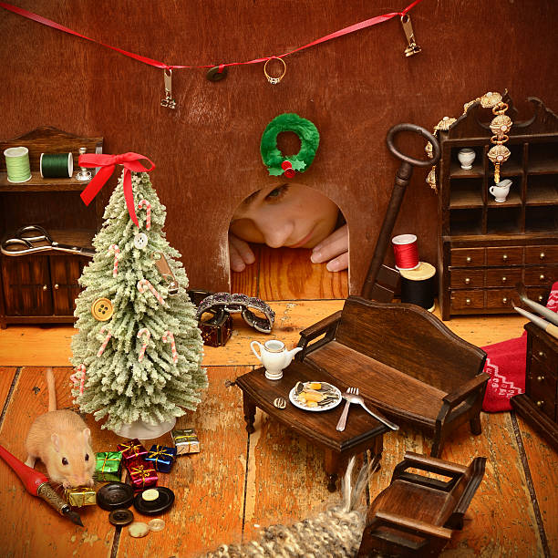 Inside a Mouse Hole at Christmas A girl peeks into a mouse hole in the wall and discovers a mouse's living room decorated for Christmas.  (The part of the mouse is played by a gerbil.) mouse animal photos stock pictures, royalty-free photos & images