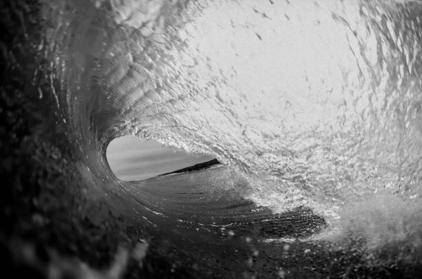Inside the perfect wave in black and white stock photo
