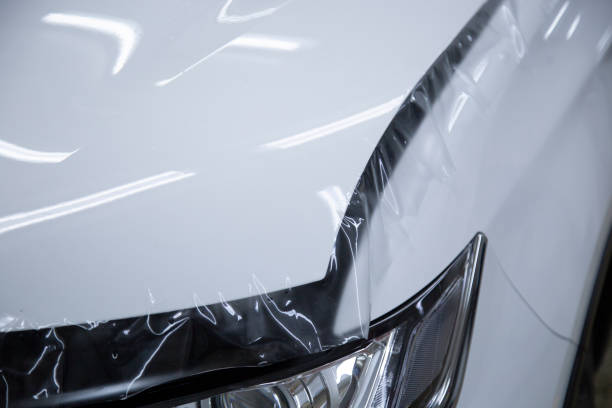 Installation of a protective film on the car body. stock photo