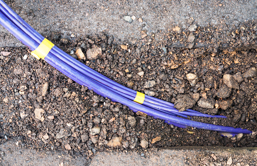 A bundle of fibre optic cables during installation below the pavement surface for high speed broadband services.