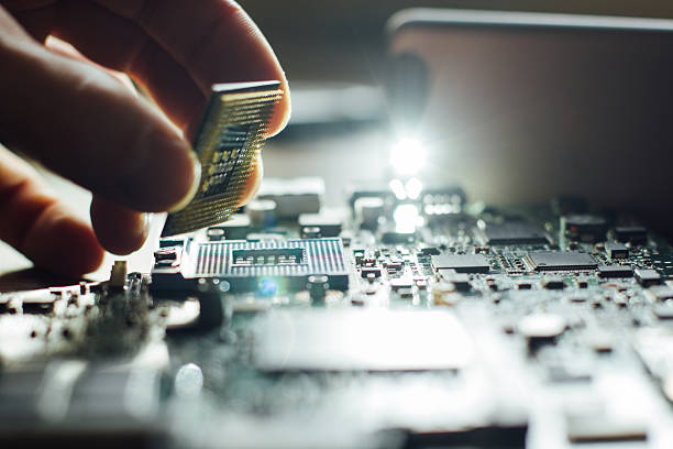 Installation of processor in CPU socket Technician plug in CPU microprocessor to motherboard socket. Workshop background computer part stock pictures, royalty-free photos & images