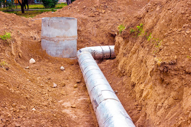 Installation of the distribution unit of heating and water supply network. Frame for connecting pipes in the trench of ground stock photo