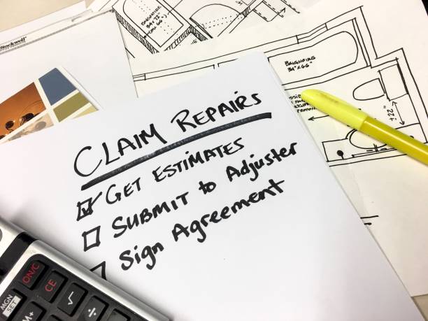 Insurance Claim Repairs and Payment Checklist Blueprints Calculator on Desk  home insurance claim form stock pictures, royalty-free photos & images