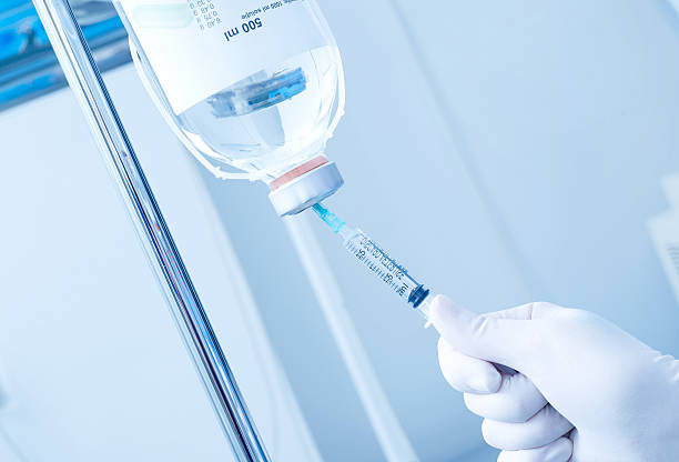 Intensive care Hand with protective glove, syringe and infusion infusion therapy stock pictures, royalty-free photos & images
