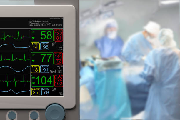 Intensive care unit monitor and ongoing surgery in background stock photo