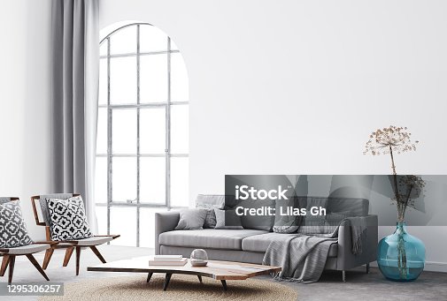 istock interior living room design with simple white background mock up. Modern grey sofa with cushions and plaid , blue vase, dried flowers and natural wooden 1295306257