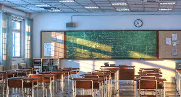 interior of a school classroom with wooden desks and chairs. stock photo