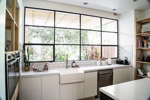 Interior view of modern kitchen with worktop sink window and shelf