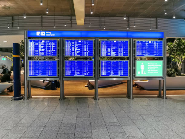 Interior view of the Frankfurt airport building,departure information board and public airport lounge with people waiting as background stock photo