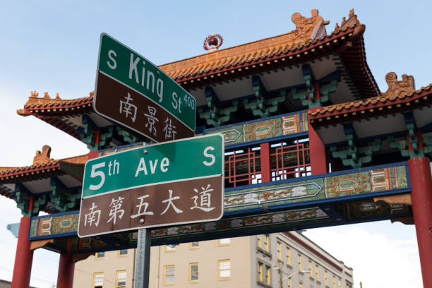 International District The Chinatown Gate and street signs. chinatown stock pictures, royalty-free photos & images