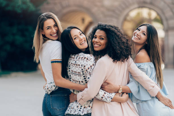 International frendship holding together Group of friends holding together and looking back female friendship stock pictures, royalty-free photos & images