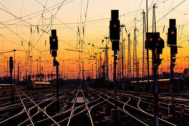 Intertwined railroad tracks with traffic lights at sunset stock photo