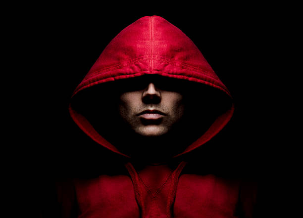 Intimidating Hooded Male Intimidating male in a red hood, part of a gang. gang stock pictures, royalty-free photos & images
