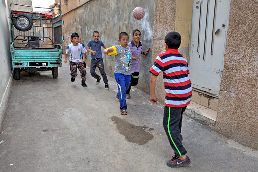 Fars Province, Shiraz: Iranian street boys playing soccer in yard.