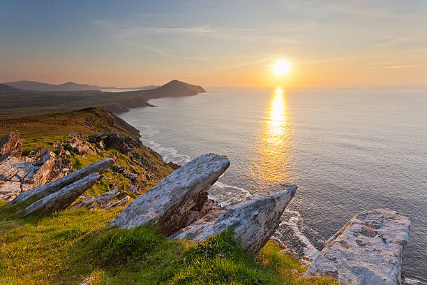 irish coastline at sunset ocean view from high cliffs overlooking dingle coastline with setting sun county kerry stock pictures, royalty-free photos & images