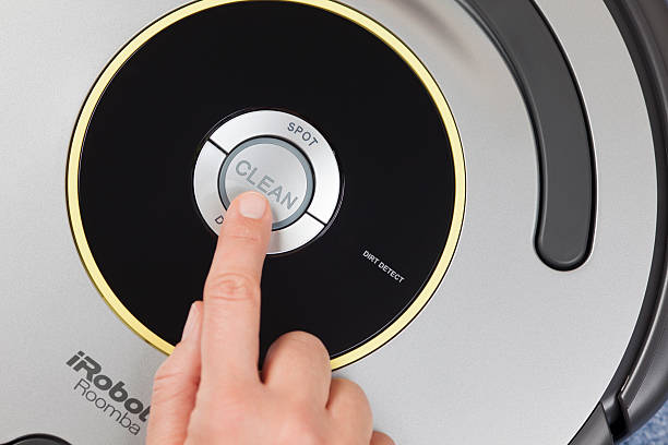 iRobot Roomba Vacuum Cleaning Robot Tambov, Russian Federation - January 26, 2014: iRobot Roomba 630 Vacuum Cleaning Robot. Woman's finger pressing the button "Clean" to starting cleaning. Studio shot.  roomba stock pictures, royalty-free photos & images