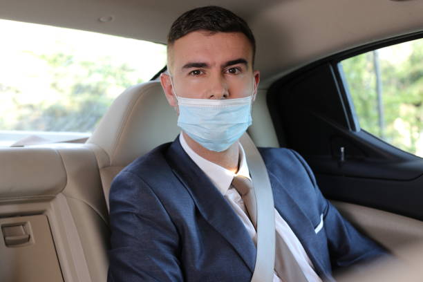 Irresponsible businessman using protective mask the wrong way stock photo