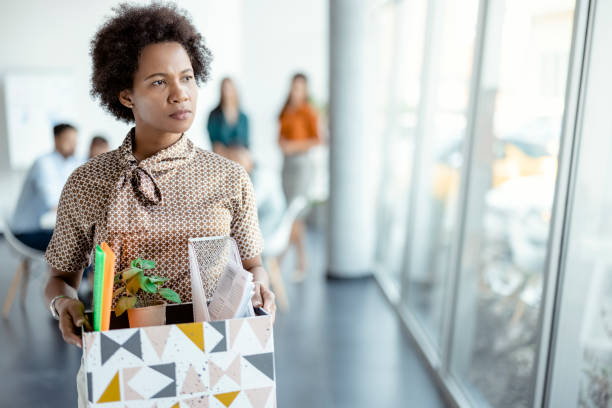 Is this how it ends Mature african woman getting fired from work. Female walks through the office, carrying box with personal belongings. Business, firing and job loss concept quitting a job photos stock pictures, royalty-free photos & images
