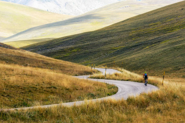 A Isolated Cyclist uphill on a Mountain Road of Campo Imperatore - Abruzzo -Italy stock photo