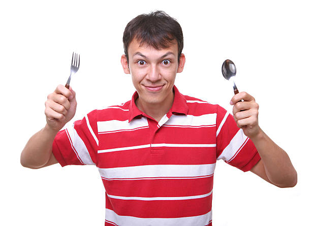 isolated hungry young man student with spoon and fork stock photo