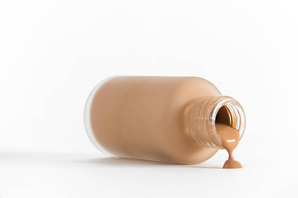 Isolated image of bottle of make-up on its side pouring out Fluid foundation foundation cosmetics stock pictures, royalty-free photos & images