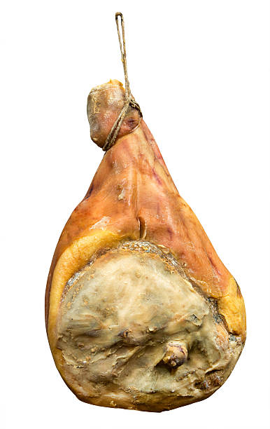 Isolated Italian Parma prosciutto ham on hook Isolated large piece of Italian Parma ham hanging from hook as if on display or for sale prosciutto stock pictures, royalty-free photos & images