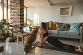 Women at home during pandemic isolation doing online yoga class