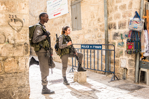 Jerusalem, Israel - November 3, 2015: Israeli soldiers - man and woman - guarding one of the mai street in old city