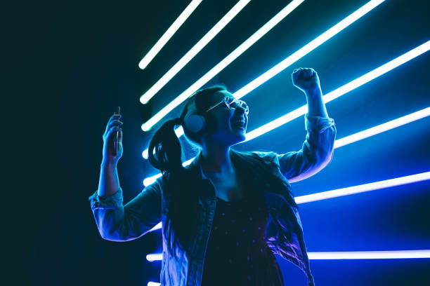 istening electronic music Woman in headphones listening music and dancing in neon light. neon lighting photos stock pictures, royalty-free photos & images