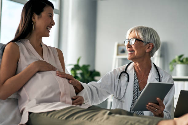 It looks like baby is perfectly healthy Cropped shot of a pregnant woman having a consultation with a female doctor obstetrician photos stock pictures, royalty-free photos & images