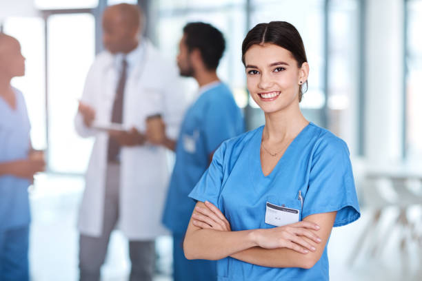 It would be a pleasure to care for you Portrait of a young medical practitioner standing with her arms crossed in a hospital female nurse stock pictures, royalty-free photos & images