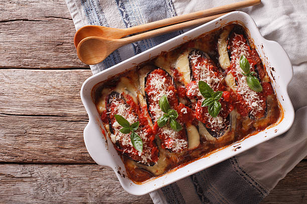 Italian eggplant baked with mozzarella in tomato sauce Italian eggplant baked with mozzarella in tomato sauce close up in baking dish. horizontal view from above eggplant stock pictures, royalty-free photos & images