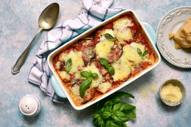 Italian eggplant dish eggplant aubergine with parmesan cheese Italian eggplant dish melanzane alla parmigiana on a light blue slate, stone or concrete background.Top view with copy space. eggplant stock pictures, royalty-free photos & images