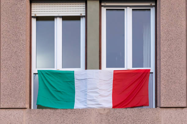 Italian flag displayed on the windows of buildings throughout Italy. stock photo