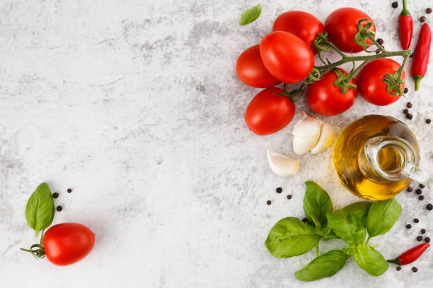 Italian food background. Fresh colorful tomatoes, basil and olive oil on white table. Top view with copy space olive fruit photos stock pictures, royalty-free photos & images