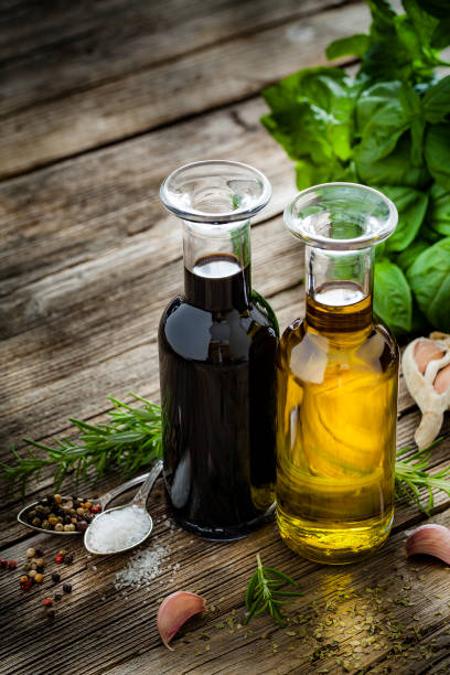 ingredienti italiani: olio d'oliva e aceto balsamico su tavola rustica - erba italiana foto e immagini stock