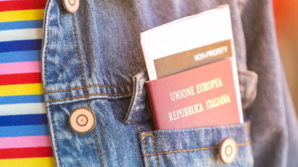 Italian passport and boarding pass in the front pocket of the jeans jacket -  woman awaiting departure flight in waiting hall - concept of independence and easy traveling in Europe stock photo